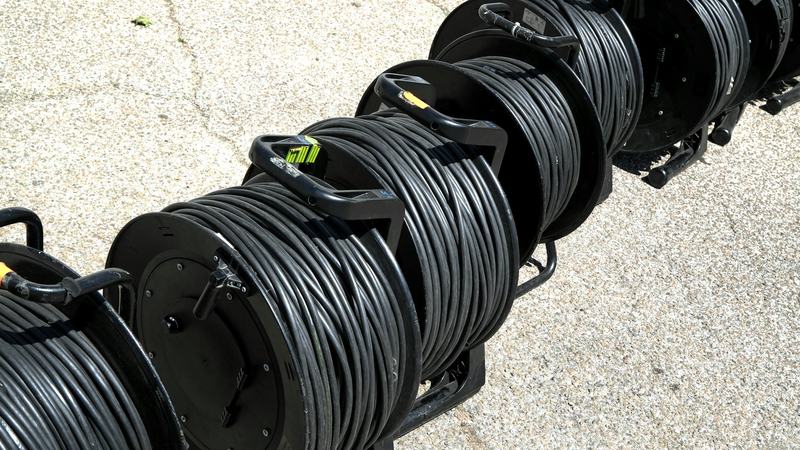 Drums of black power cable on a concrete floor